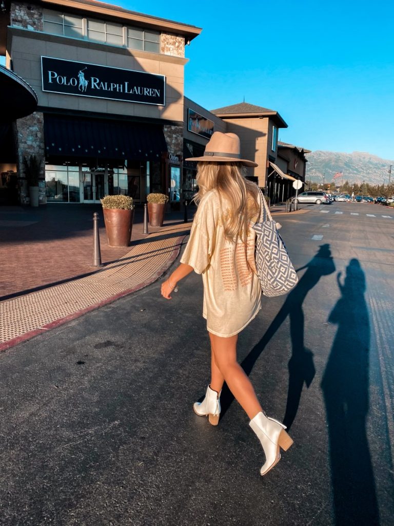 blonde girl walking to the mall in white booties and a tshirt dress