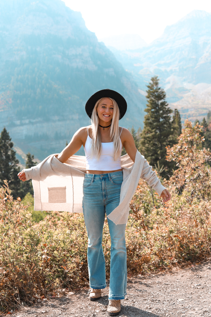 girl smiling in a fall mountain wearing bell bottom jeans
