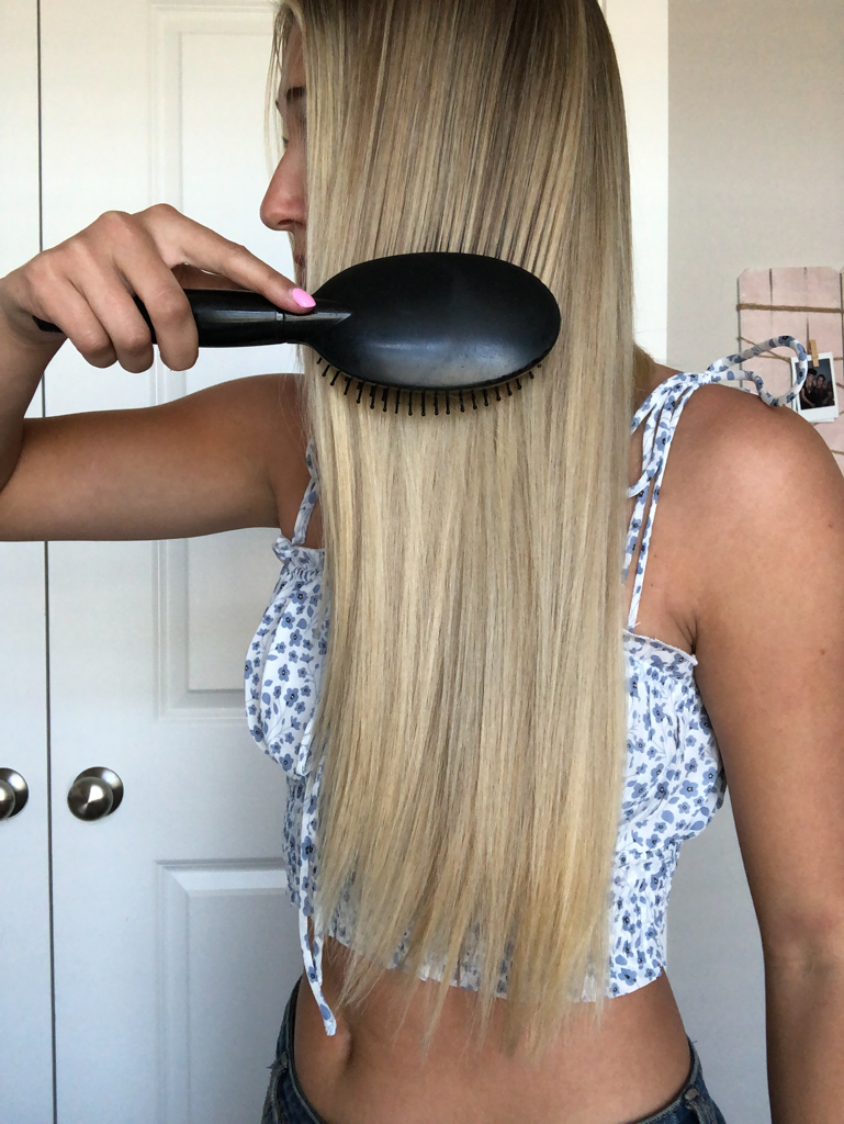 girl brushing her long blonde hair