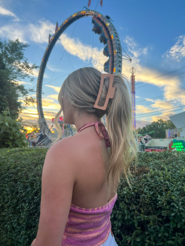 blonde hair in claw clip at a carnival